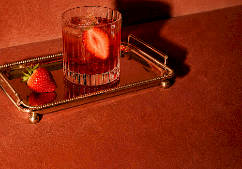 A Negroni Week promo: a pink cocktail with strawberry garnish in a glass on a gold tray, dated Sept 21&ndash;27.
