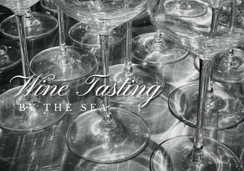 Black-and-white photo of a crowded table of wine glasses, with &ldquo;Wine Tasting by the Sea&rdquo; text overlay.
