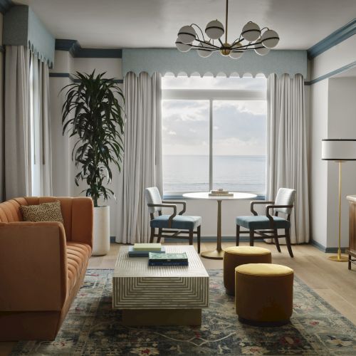 A cozy living room features a sofa, coffee table, two chairs by a window, plants, and a vintage-style sideboard under modern lighting.