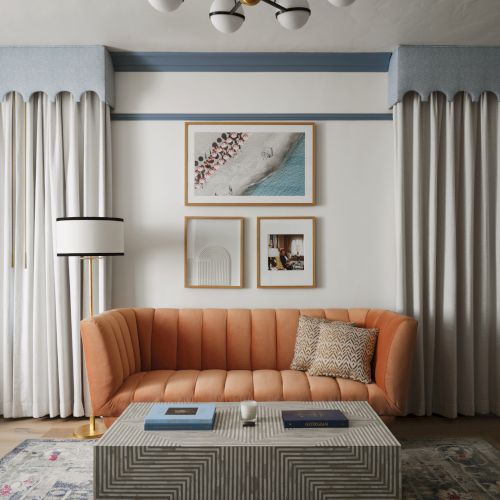 A stylish living room with a peach sofa, patterned coffee table, and wall art, complemented by elegant curtains and a modern chandelier.