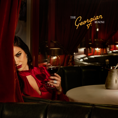 A person in red holds a wine glass, partly hidden by a curtain, in an elegant setting with "The Georgian Room" sign above.
