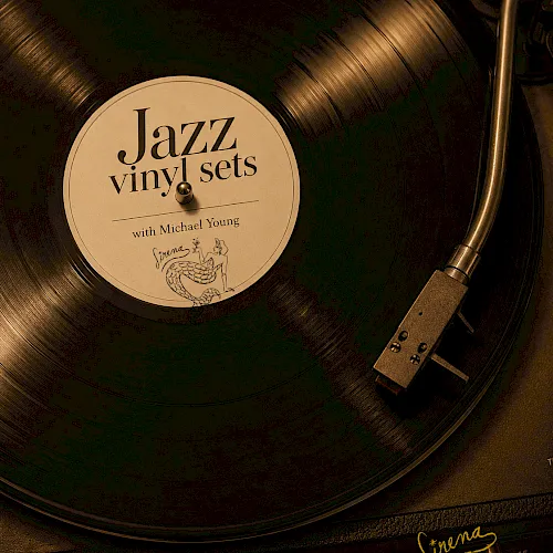 A vinyl record labeled &ldquo;Jazz vinyl sets,&rdquo; with a needle/turntable arm, plus text &ldquo;Sundays 6PM&ndash;10PM,&rdquo; all golden-toned.